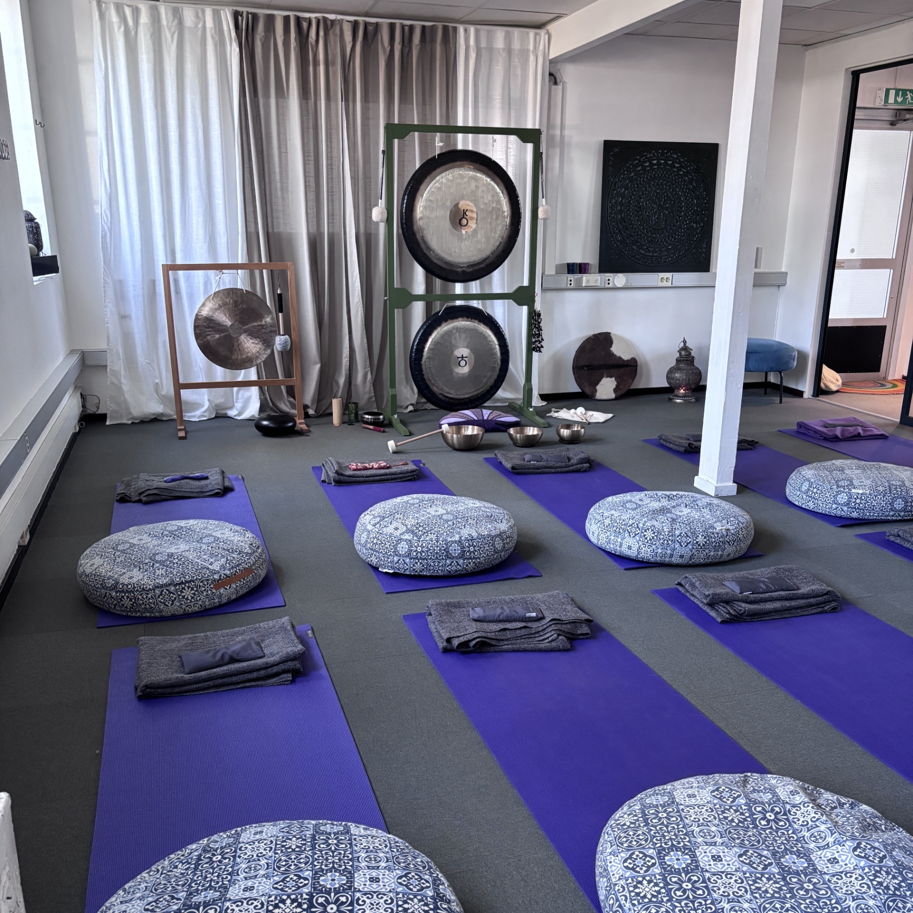 Yogalokalen med gongar, mattor och meditationskuddar